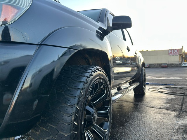 Lifted black Toyota Tacoma with detailed tires and wheels